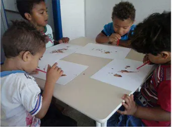 Figura 4 - Crianças fazendo pinturas com sopro 