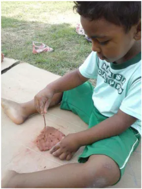 Figura 12  – Criança modelando com argila e galho 