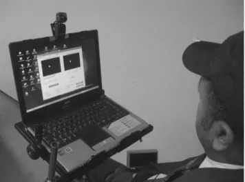 Figure 1 - User with the pointing device composed of computer software,  a webcam-type camera, and a relective target attached to the brim of a cap