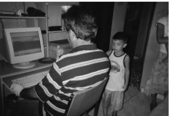 Figure 5. Ce. by his computer at his own home, and  his youngest son standing by. 