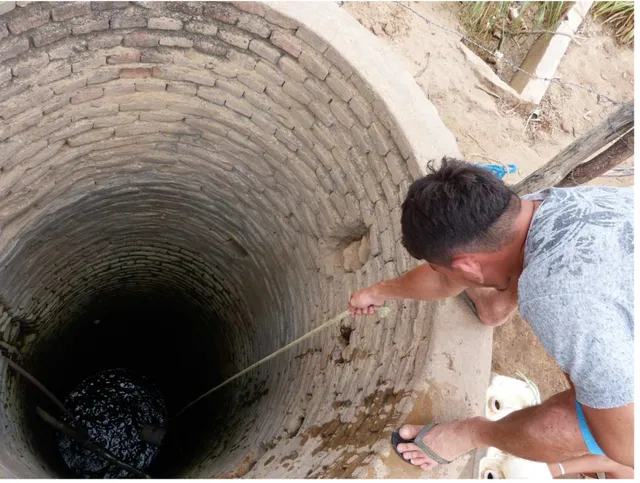 Foto  6  –  Homem  retira  água  no  “cacimbão  do  Assis”.  Esta  água  é  utilizada  para  banho,  lavagem de roupa, talheres e no cozimento de alimentos