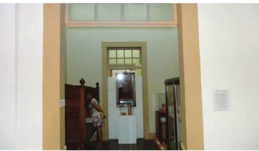 Figura 8: Na entrada para uma das alcovas, vêem-se os dois papéis brancos afixados,   o pequeno à esquerda, no batente da porta, e o maior à direita, sobre a parede