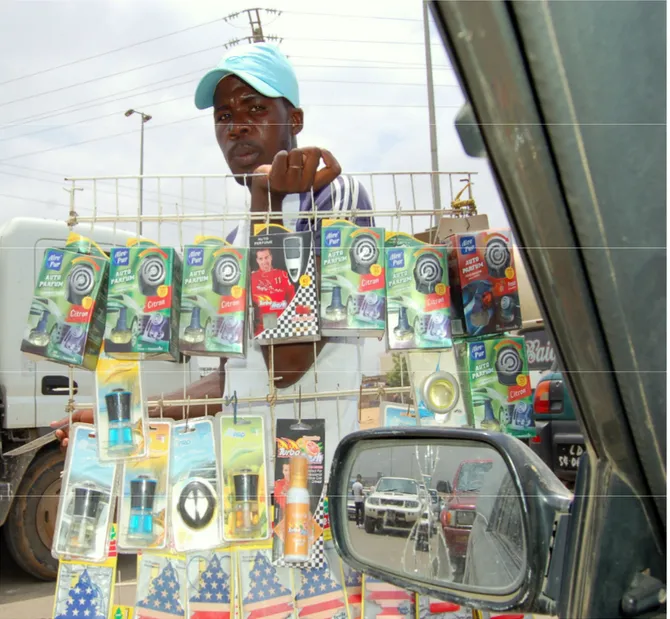 Figura 0 – Jovem Zungueiro vendendo entre os carros na Avenida 1º de Maio Foto: Bernardino Cuteta ; 2011
