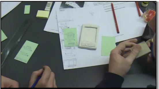 Figure 4.4: Participants working on sketches while testing them on one of the frames.