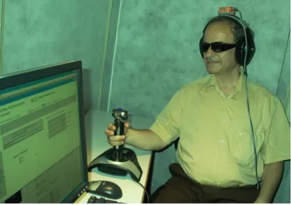 Figure  3  –   Individual  who  is  blind  performing  virtual  navigation  using  a  joystick  (haptic input) and wearing headphones (audio output) equipped with orientation sensor