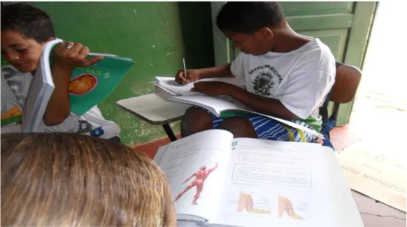 Figura  2 – Educandos  utilizando os Cadernos de Ensino e Aprendizagem da Área de Ciências           Naturais do PEA do 3º ao 5º ano em sala de aula 