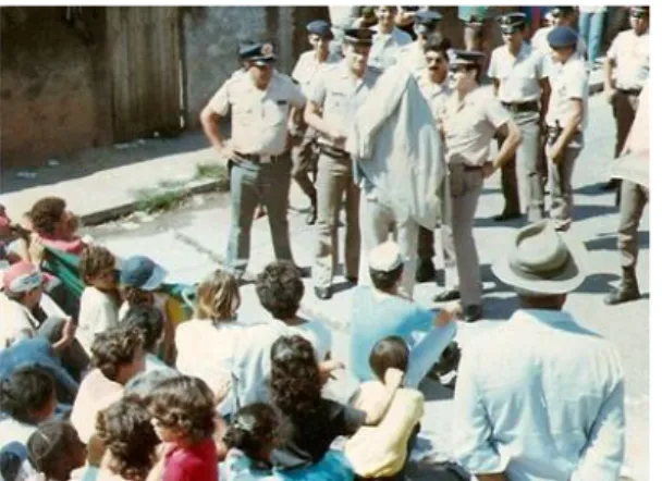 Figura 5: Mulheres e crianças sentadas à frente da Fábrica, impedindo a entrada dos  militares