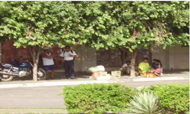 FOTO 06: Pessoas A’uwê com suas compras na Porta da Academia Mato-Grossense de Letras  aguardando o caminhão para retornarem a sua aldeia