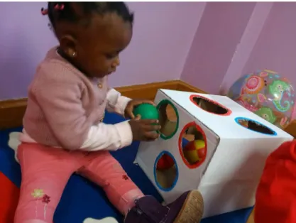 Figura 1 - Criança a explorar a caixa e as bolas.