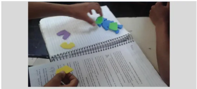 Figura 49 -Imagem de um aluno utilizando os bonecos de papel  Fonte: Arquivo pessoal da pesquisadora 