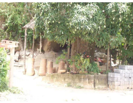 Foto 2: Vasos e panelas expostos para venda na entrada da casa de Vagna.   Ao fundo está o forno onde as cerâmicas são queimadas