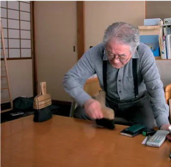 FIG. 4 – The Hyôsô-shi, Mr Yamamoto demonstrating the correct brushing action needed to put moisture back into a screen.