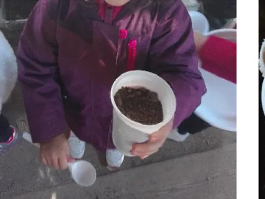 Figura  8:  A  criança  mostra  que  fez  o  sumo de laranja utilizando para o tal, o  copo de plástico, solo e areia