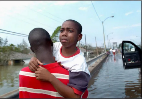 Figura 4 - Milhares de famílias tiveram as casas submersas e ficaram  desabrigadas.  Na  foto,  pai  retira  filho  da  cidade  de  New  Orleans  e  busca local seguro para se protegerem