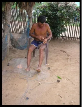 Foto 14 - Seu Olivar, Pescador artesanal da APA – consertando  rede caiqueira .   Fonte: Benilde Rosa – pesquisa de campo (agosto de 2005) 