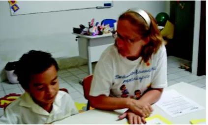 Foto 1: A foto ilustra uma atividade de avaliação com um aluno com deficiência intelectual na sala de recurso multifuncional da Escola Padre Felice Pistoni, na cidade de Fortaleza