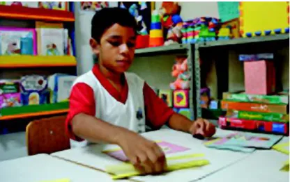 Foto 2: A foto ilustra uma criança com deficiência intelectual em  aten-dimento na sala de recurso  multi-funcional na escola Padre Felice Pistoni, na cidade de Fortaleza