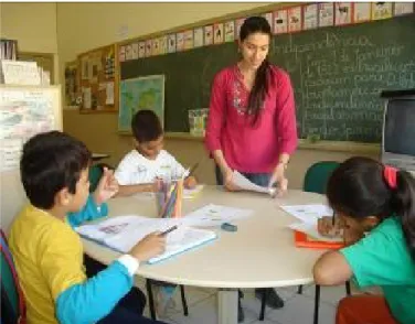 Foto 1 – Mostra uma sala de recursos multifuncional e a professora ensinando Língua Portuguesa escrita para  crianças com surdez