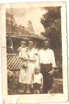 Foto 5: Zulmira com marido e filhos (fundo, casa de madeira). 