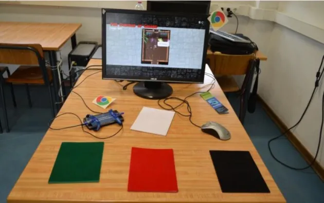 Figure  2-33. The Dungeon of Colors’ setting: a browser displaying the DoC  scenario  (DoCWebApp),  a  smartphone  running  both  DoCMobileApp  and  EveWorks (to the left of the white pad) and four colored pads with embedded  NFC tags