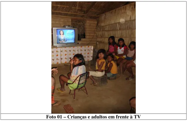 Foto 01 – Crianças e adultos em frente à TV  