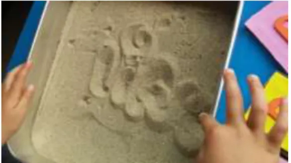 Figura 15 - Criança a escrever o nome na areia 