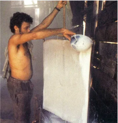 Figura 16: Foto de seringueiro banhando tecido de algodão com  látex natural
