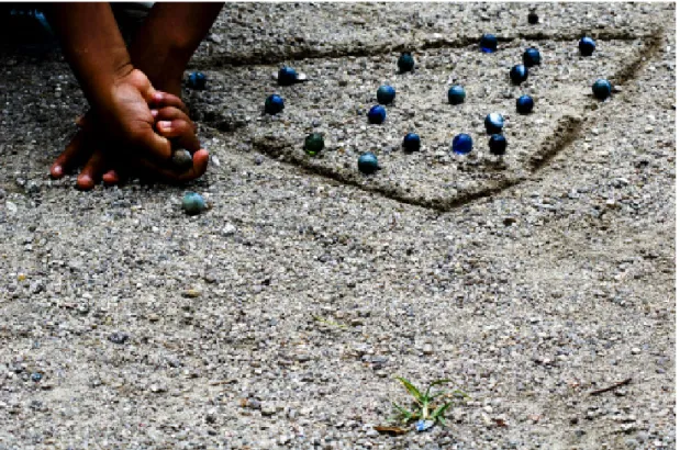 FIGURA 1 - Criança brincando de bola de gude. Nova Holanda, Favela da Maré – Rio de Janeiro.