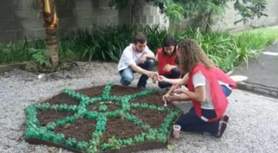 Figura 4: Estudantes plantando as sementes de hortaliças na terra e nos copos plásticos