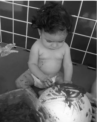 Figura 1- Bebê manuseando tinta comestível em pintura de globo
