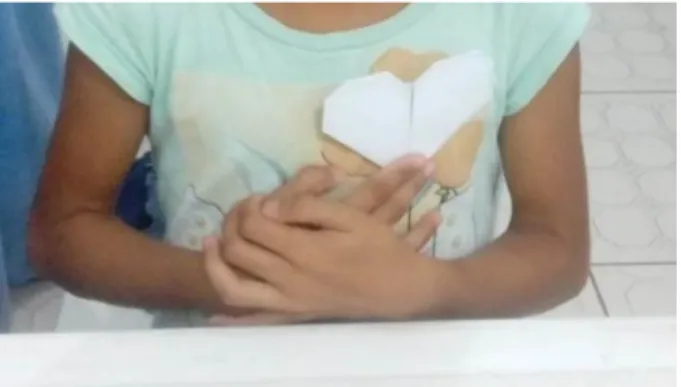 Figura 05. Aluna com o origami de coração. 