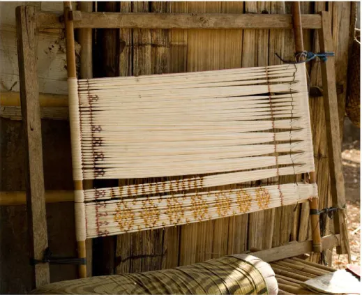 Figure 1. The warp ikat process: making the resists. Warp threads stretched on a frame, with partly tied ikat resists, on the island of Alor.