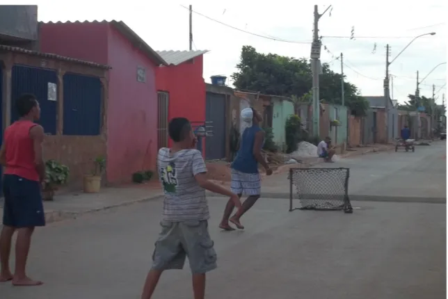 Figura XII – meninos jogando futebol num campo improvisado nas ruas do Itapoã