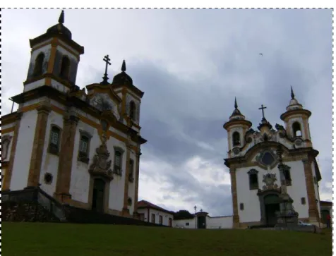 Foto 02  –   Praça Minas Gerais, em Mariana, com duas igrejas  da Ordem Terceira, o pelourinho – defronte às duas igrejas – e,  ainda, a Casa de Câmara e Cadeia, símbolo máximo, em Minas  Gerais,  de  uma  teatralidade  barroca  e  controle  socioespacial