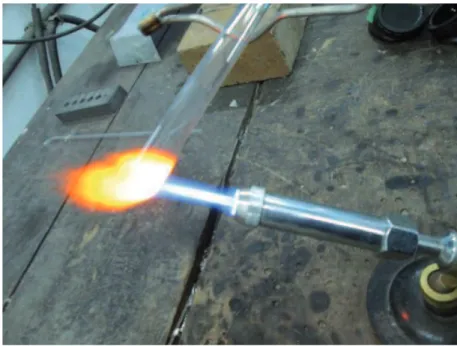 Figura 6 - Extremidade do tubo de borossilicato sendo aquecida com a chama de maçarico