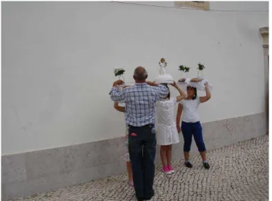 Figura  9  –  Ao  término  da  procissão  de  Nossa  Senhora  da  Gaiola,  em  Cortes,  Leiria,  os  pais  ensinam  seus  filhos  a  segurarem  as  bandejas  na cabeça