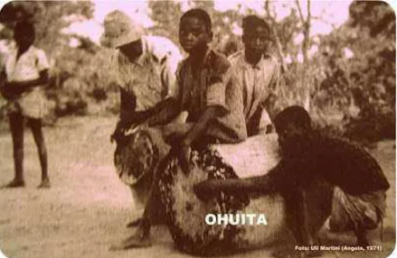 Figura  4:  Meninos  percutem  e  friccionam  ao  mesmo  tempo  a  grande  ohuita  dos  ovimbundu  do  planalto de Benguela, Angola