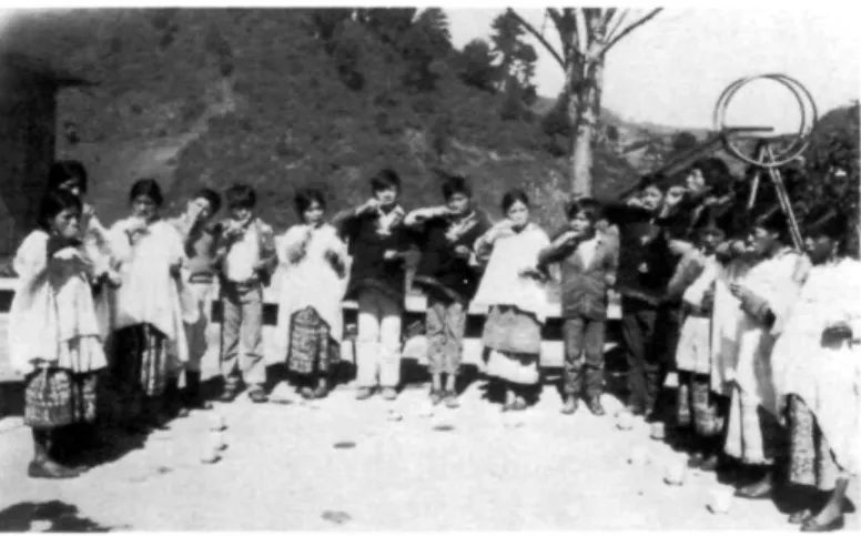 Foto 2. Un grupo de escolares de Santa Eulalia Huehue efectúa  autoaplicaciones de flúor bajo la supervisión de un promotor (quien  no aparece en la fotografía)