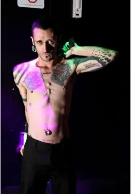 Figura  3  -  Uma  visão  geral  do  corpo  do  performer  T.  Angel.  Notem-se  as  diversas  tatuagens,  os  três  implantes  3D  subdermais,  alargadores  nas  orelhas,  e  piercings  (em  destaque,  um  deles  no  umbigo).Foto:  Thiago  Marzano