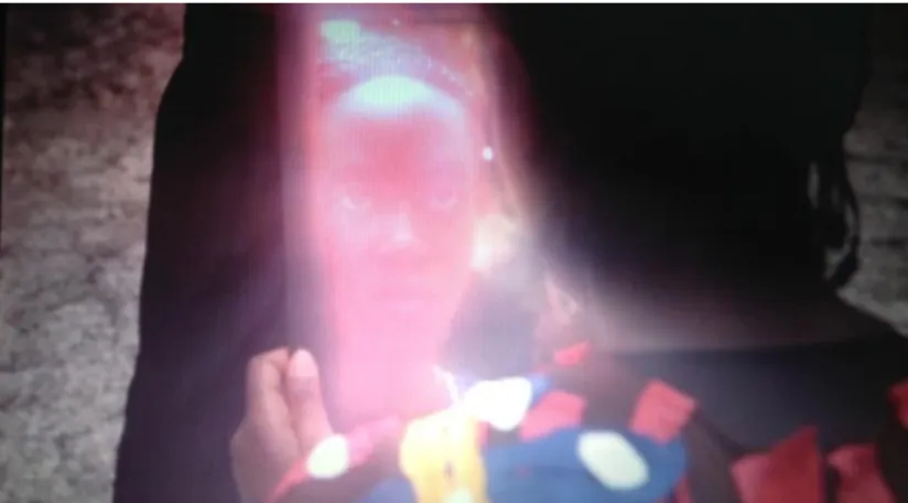 Figura 3 -  Instante no qual a atriz haitiana Axelle Murizero se mira no espelho que será jogado no  chão  no  vídeo  interativo  Just  a  reflektor  de  Vincent  Morriset,  2013