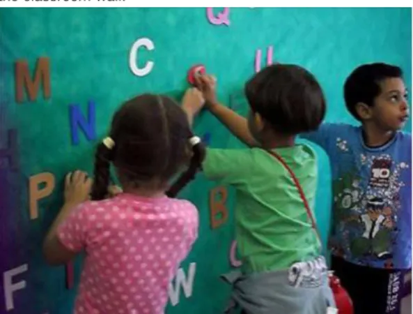 Figure 8- Júlio “sculpts” the letter “S” by placing the clay on  the classroom wall.