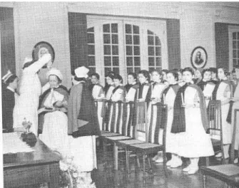 Figure 1 shows Bertha Pullen, helped by Zaíra Cintra Vidal, puts the coif in the head of one of the students, while the student lights her candle on the flame of the previous student’s candle
