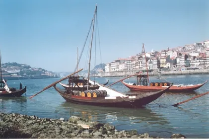 Figura 2 – Barcos rabelos en las márgenes del río Duero junto a la ciudad de  Oporto. El antiguo  poblado de Portucale seria el embrión del reino de Portugal que se alargaría hacia el sur hasta el 