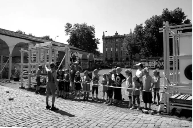 Figure 2  : Workshop de construction de jeux temporaires avec des enfants du quartier sur le quai  des Matériaux, futur parc Beco, au bord du canal à Bruxelles ; en arrière-plan l’avenue du Port et  les entrepôts royaux de Tour et Taxis