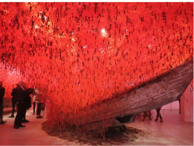 Figure 3 – Chiharu Shiota, The Key in the Hand, 2015, Installation, fil rouge, clés, bateaux de  bois, une photographie et quatre moniteurs vidéos, Pavillon japonais de la Biennale de Venise,  Venise