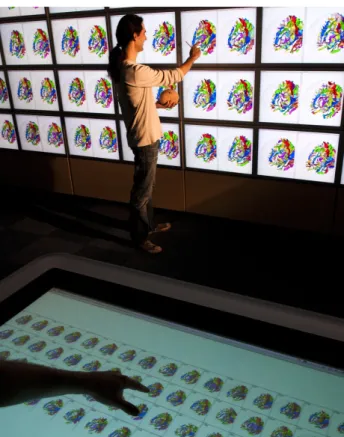 Figure 1: Multi-surface interaction with the BrainWall: multi- multi-ple users interact with a table, wall-sized display, and physical interface props.