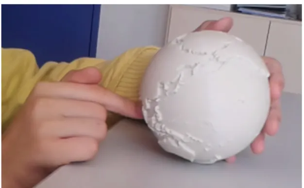 Figure 1. Probe 1 : un globe aux continents en relief, imprimé en 3D. Il est ici manipulé par un enfant, qui l’explore tout en le faisant