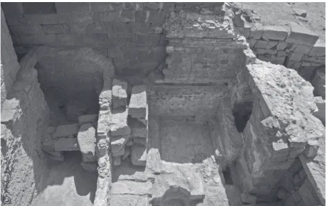 Fig. 4    Vue de la citerne 9 et de la salle froide  4. Contre le mur du fond (M10), le  parement de petits moellons de basalte  supportant le départ de la voûte qui  couvrait cette salle