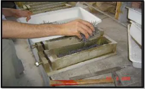 Figure I.3.1 : Placement à la main des fibres d'acier dans un moule  