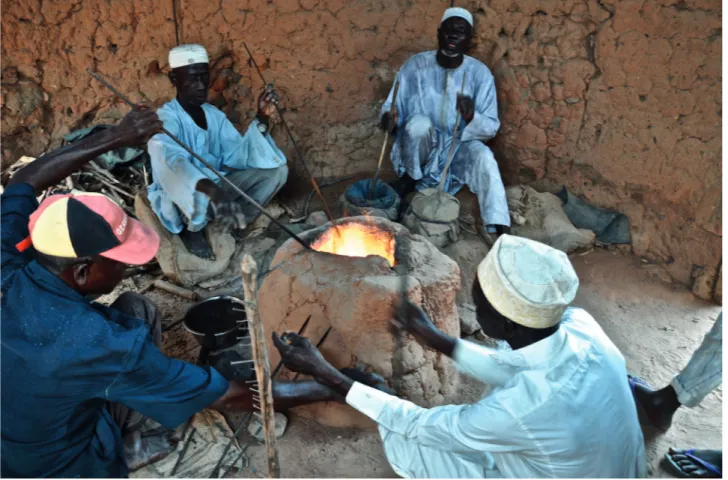 Fig. 3 – Artisans verriers de Bida, Nigeria. Autour du four, trois verriers fabriquent des bracelets tandis qu’un quatrième artisan actionne  les soufflets pour obtenir une température suffisante. (Photographie L.Lababidi)
